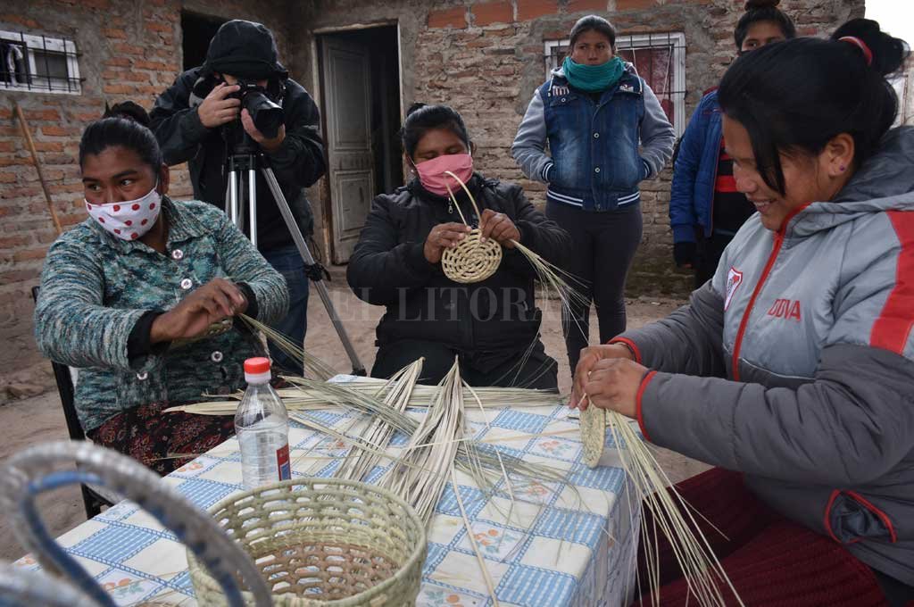 ARTESANAS. No importa si hace frío o calor. Las mujeres de Qom Alphi se reúnen todas las mañanas para tejer hojas de palmas y hacer hermosas creaciones Crédito: Flavio Raina