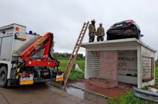 Extraño accidente Retiran el auto que quedó arriba de una garita de colectivos en Entre Ríos - Retiran el auto que quedó arriba de una garita de colectivos en Entre Ríos -